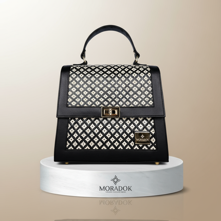 Black handbag with white pattern on a beige background, featuring the Moradok brand.